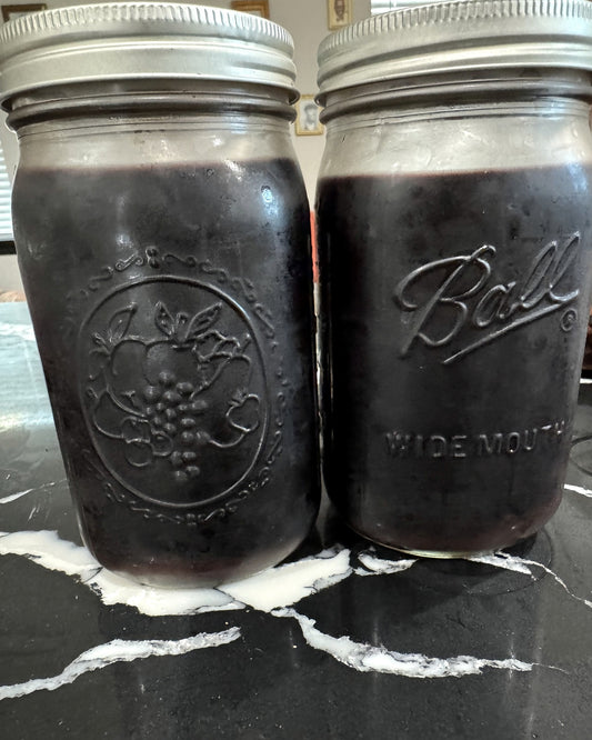 Two mason jars filled with small-batch elderberry syrup